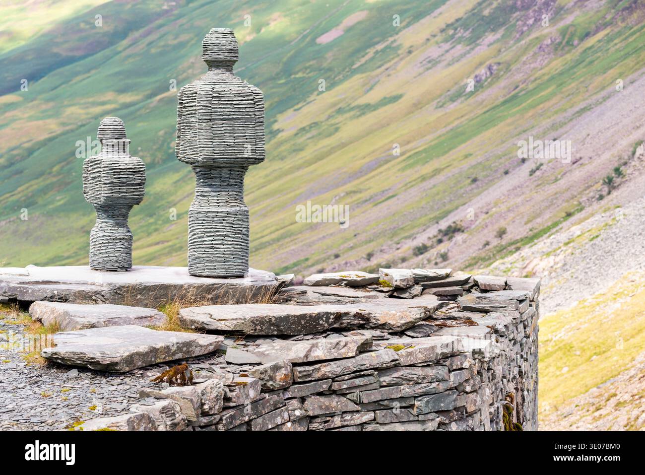 In den Bergen von Cumbrian stehen Statuen mit Blick auf ein malerisches Tal auf steilen Wänden, neben der Honister Slate Mine, einem beliebten Touristenziel und einem Stockfoto