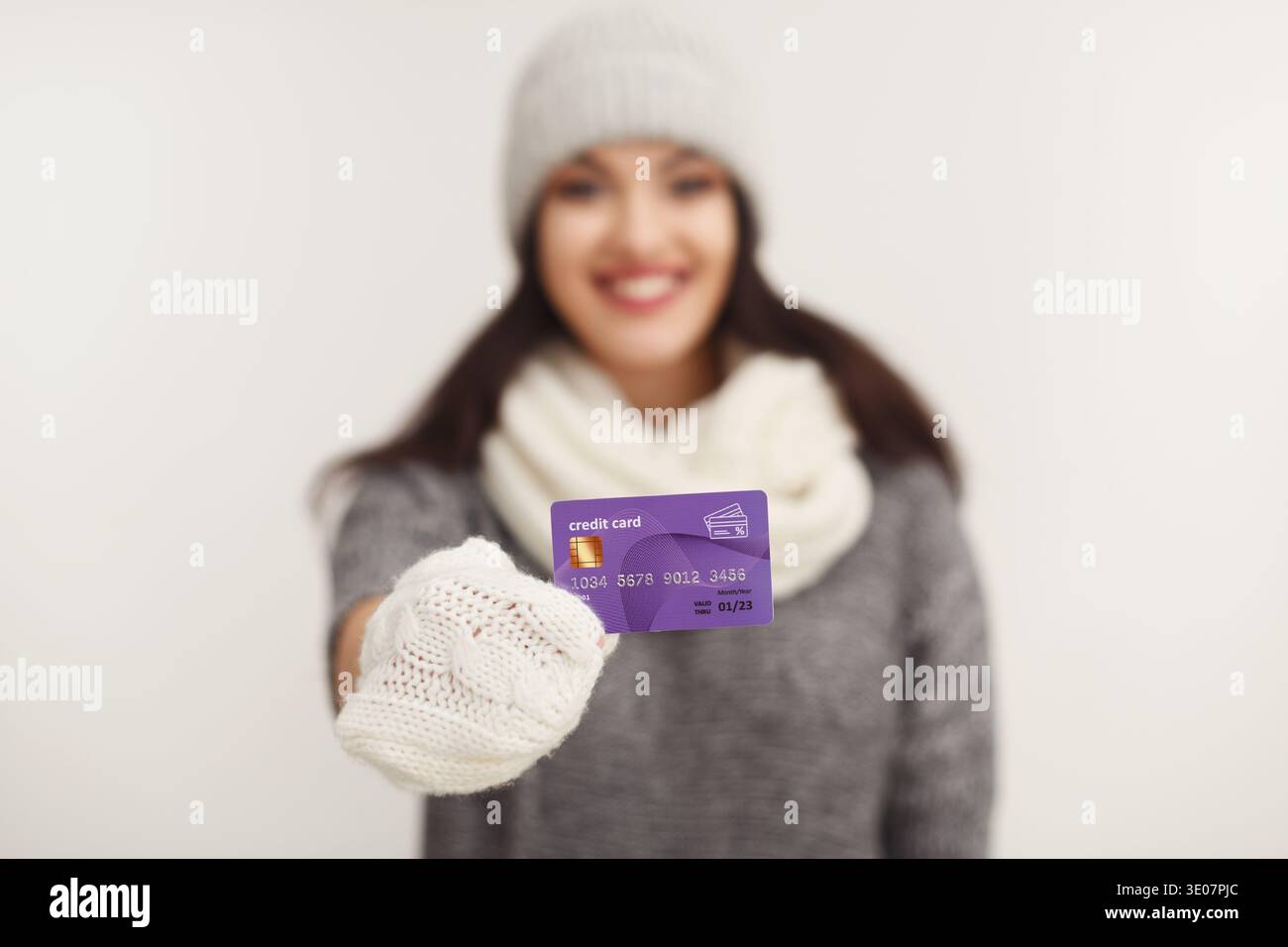 Glückliche Frau in Winterkleidung mit Kreditkarte Stockfoto