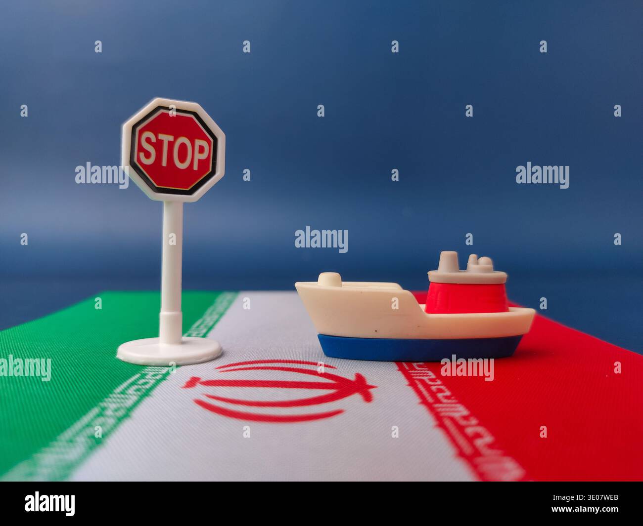 Miniaturboote und Stoppschilder auf nationalen Flaggen wurden verwendet, um politische oder wirtschaftliche Blockaden und internationale Beziehungen mit dem Iran zu repräsentieren. Stockfoto