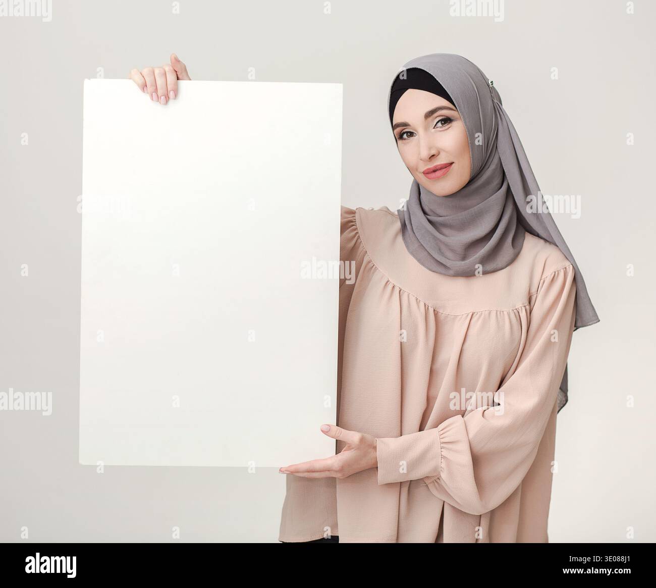 Frau im Hijab mit weißem Poster für Ramadan. Glückwunsch Stockfoto