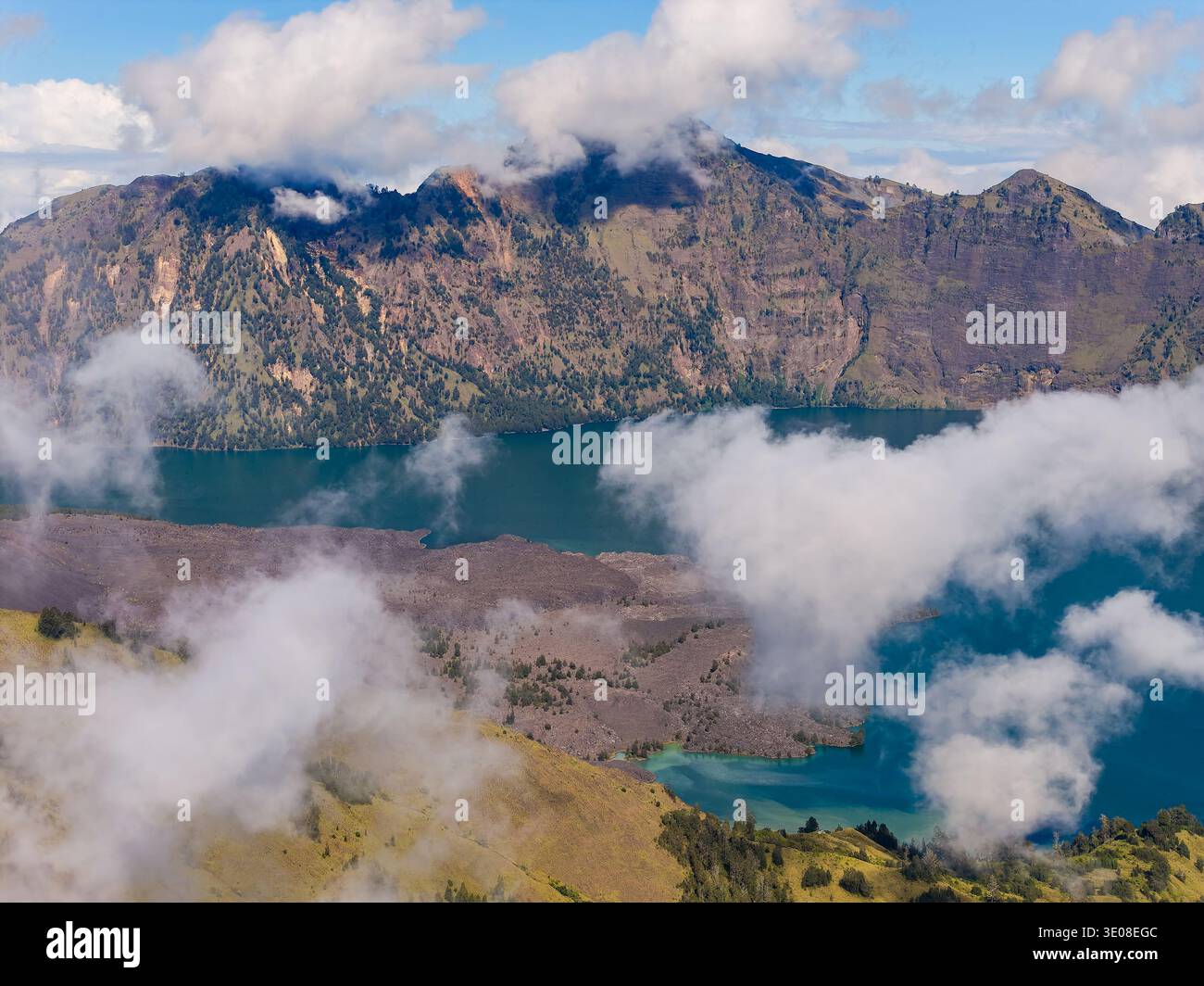 Malerischer Blick auf den vulkanischen Caldera des Mount Rinjani mit tiefblauem Wasser und dramatischen Wolken Stockfoto