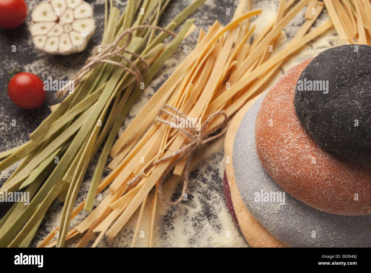 Sammlung von farbigem Teig, Pasta und Gemüse auf einer Küchenoberfläche zum Kochen Stockfoto