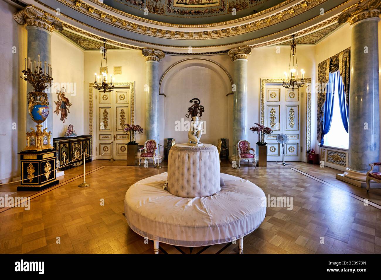 Besucher sehen das Innere des Yusupov-Palastes in St. Petersburg. Das Zimmer verfügt über eine Statue und ein elegantes Dekor. Stockfoto