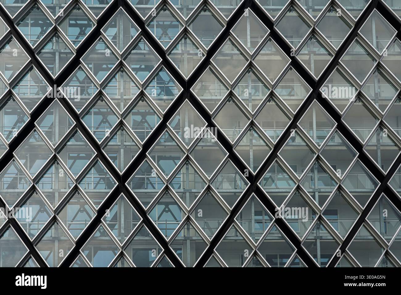 Moderne Architektur. Dynamische Glasfassade mit Rautenmuster und rhythmischen Perspektiven und industriellen Strukturelementen. Stockfoto