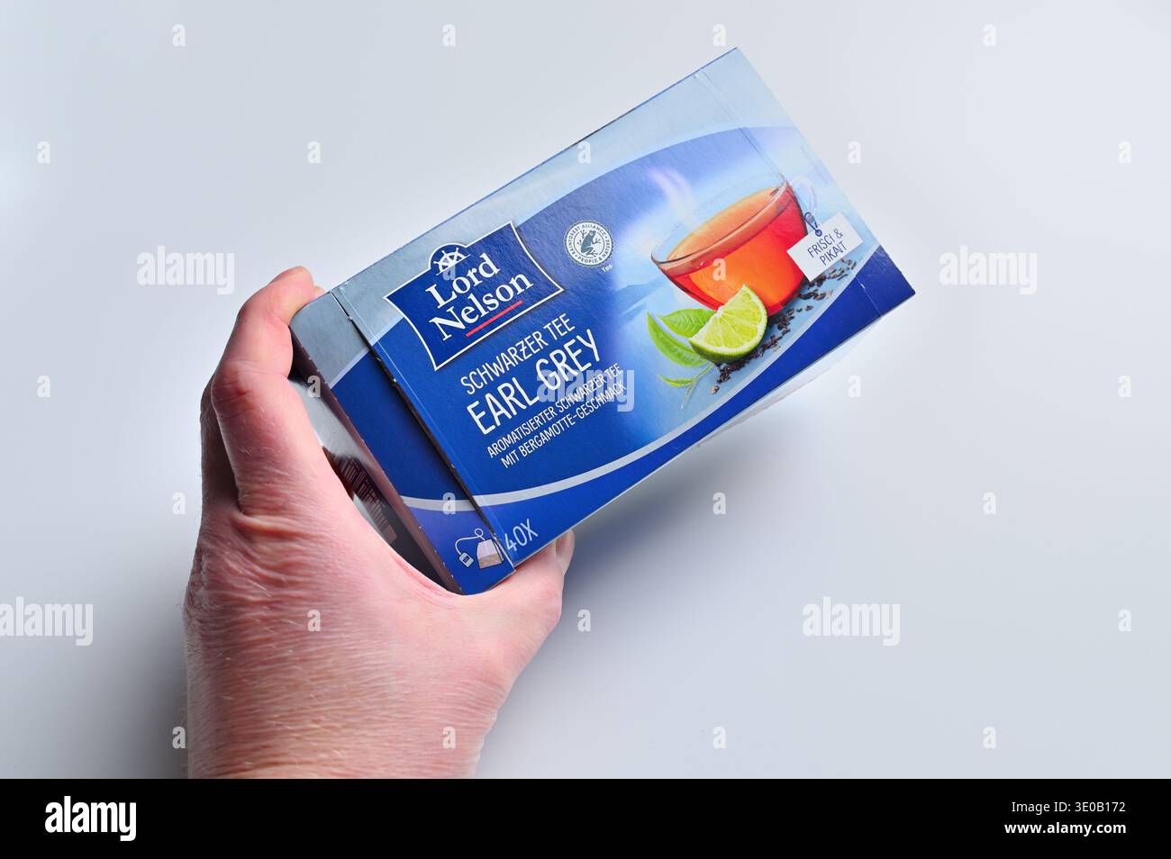 ISERLOHN, DEUTSCHLAND – 11. MÄRZ 2026: Person, die Lord Nelson Earl Grey schwarze Teebox von Lidl auf weißem Hintergrund hält Stockfoto