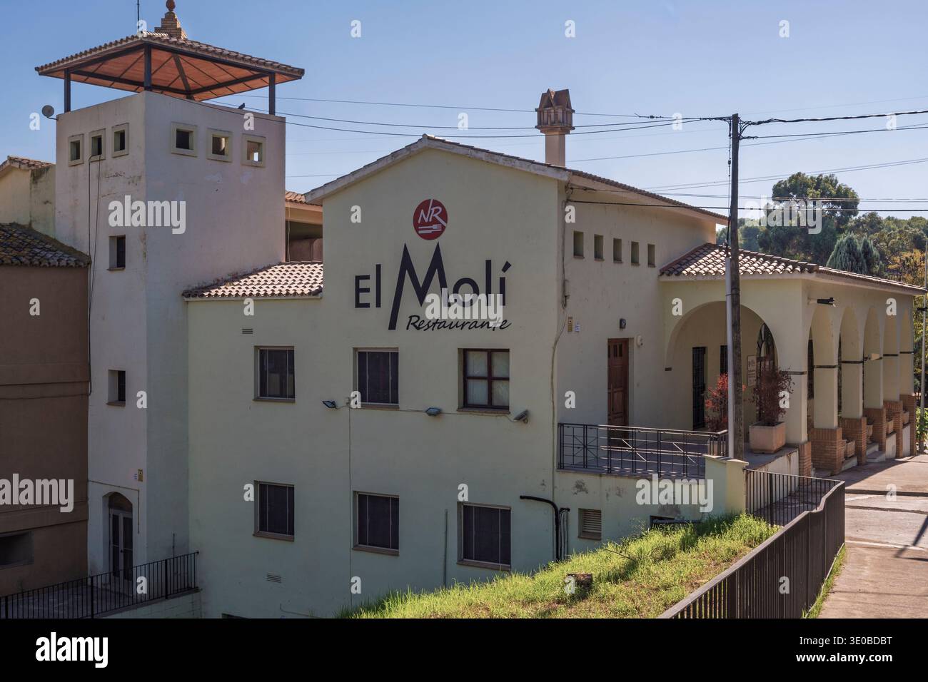 Außenansicht des El Moli Restaurante in Vila-Real, Castello, Spanien, mit traditioneller Architektur mit einem Turm und Bögen unter einem klaren blauen Himmel. Stockfoto