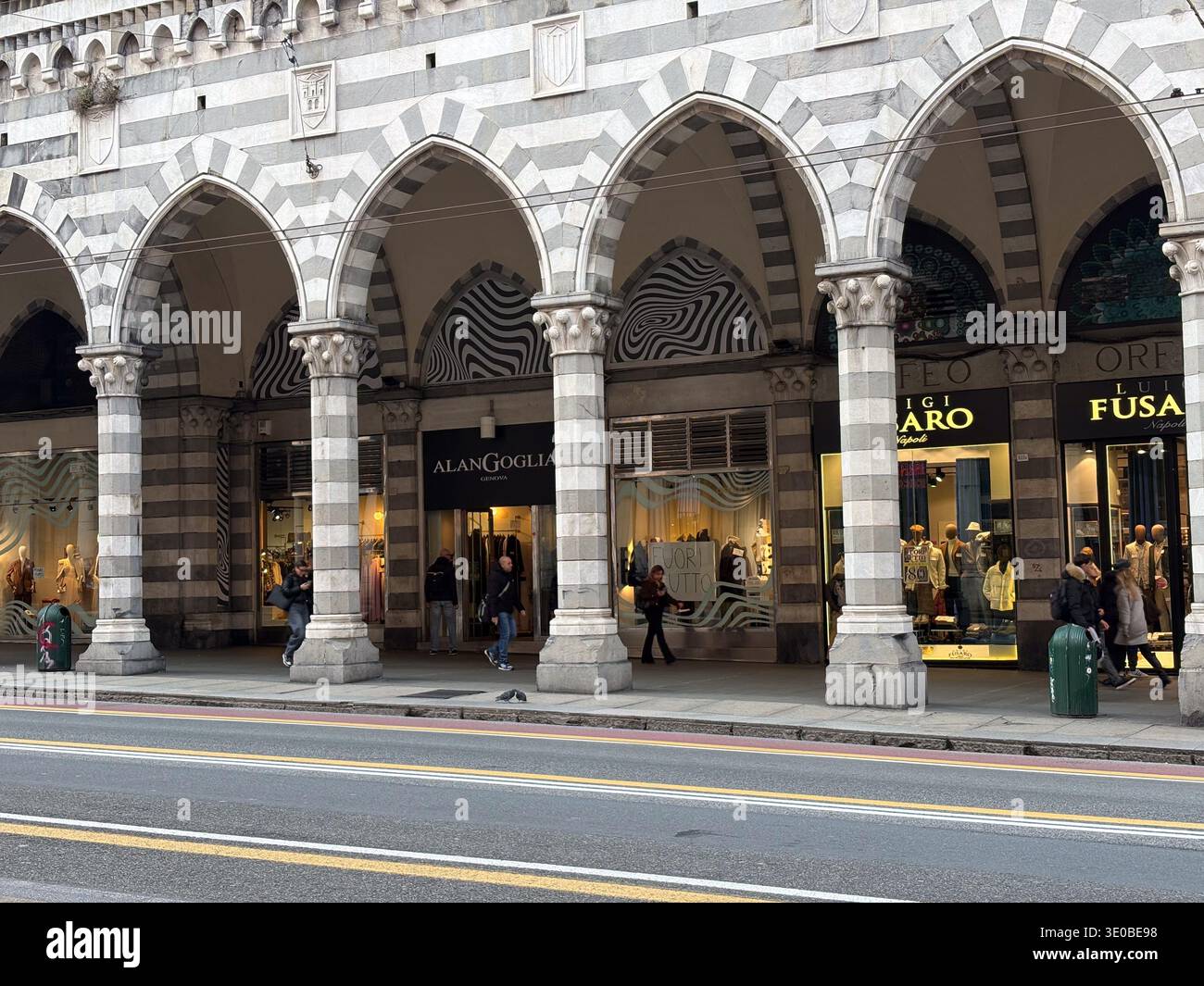 Via XX Settembre, Genua, Italien. Monumentaler Portikus aus dem 19. Jahrhundert mit gestreiften Marmorbögen und luxuriösen Ladenfronten. Stockfoto