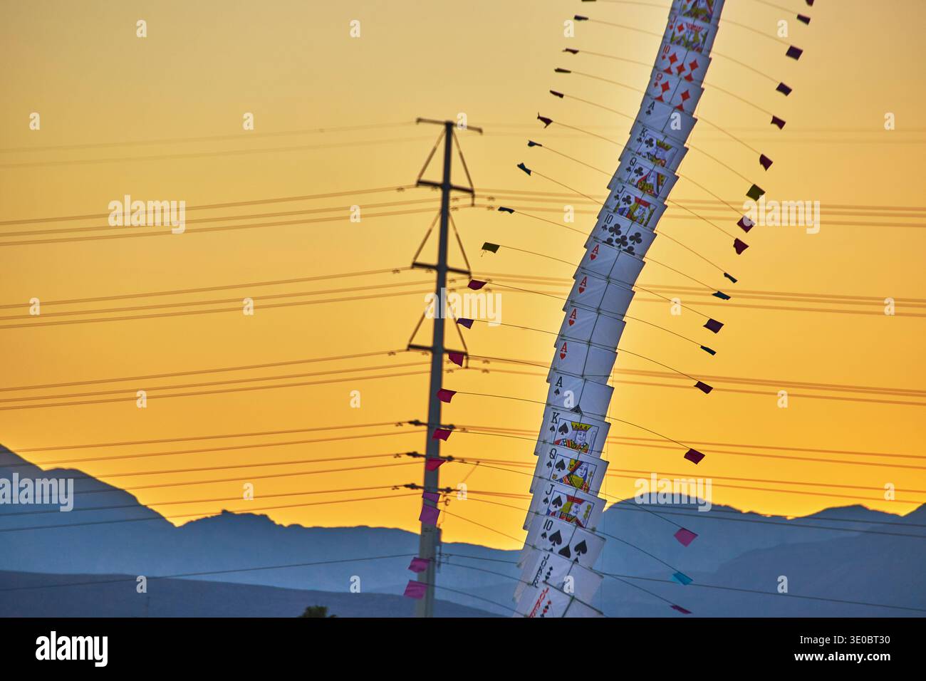 Kartenspiel beim Las Vegas Festival mit Power Lines und Sunset Mountains Stockfoto