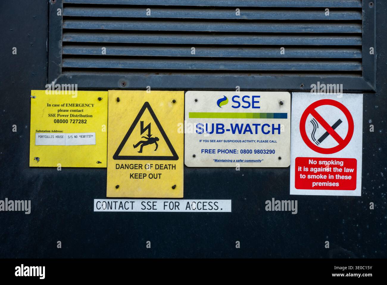 Verschiedene Notfall- und Warnschilder an der Tür zu einer schottischen südlichen Stromumspannstation, einschließlich „Todesgefahr“ und „Keep out“ Stockfoto