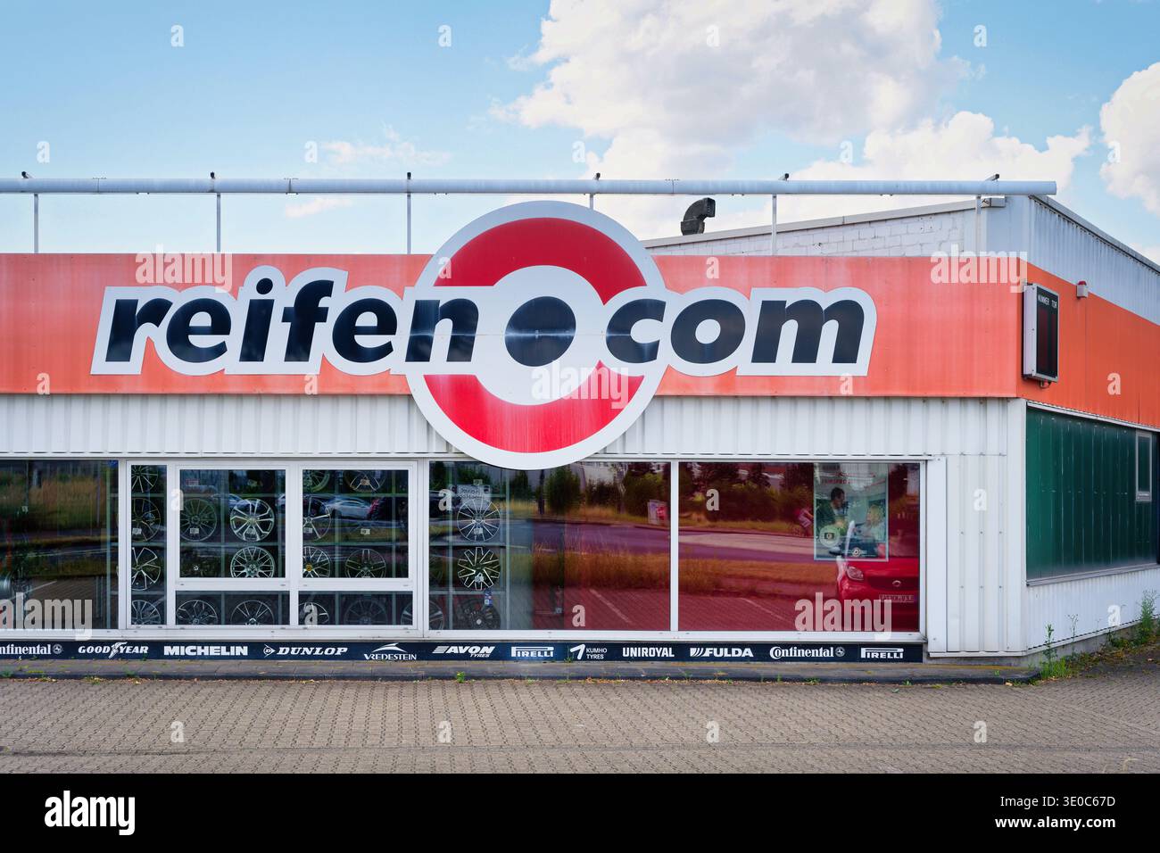 Köln, Deutschland 15. Juli 2025: Außenansicht eines Reifenhändlers reifen.com in Köln, Deutschland. Beschilderung mit verschiedenen wichtigen Reifenmarken auf einer Funktion Stockfoto