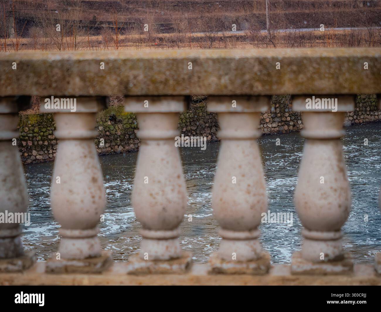 Blick auf den Fox River von der Benton Street Bridge in Aurora Illinois durch Betonbaluster der Brückengeländer Stockfoto