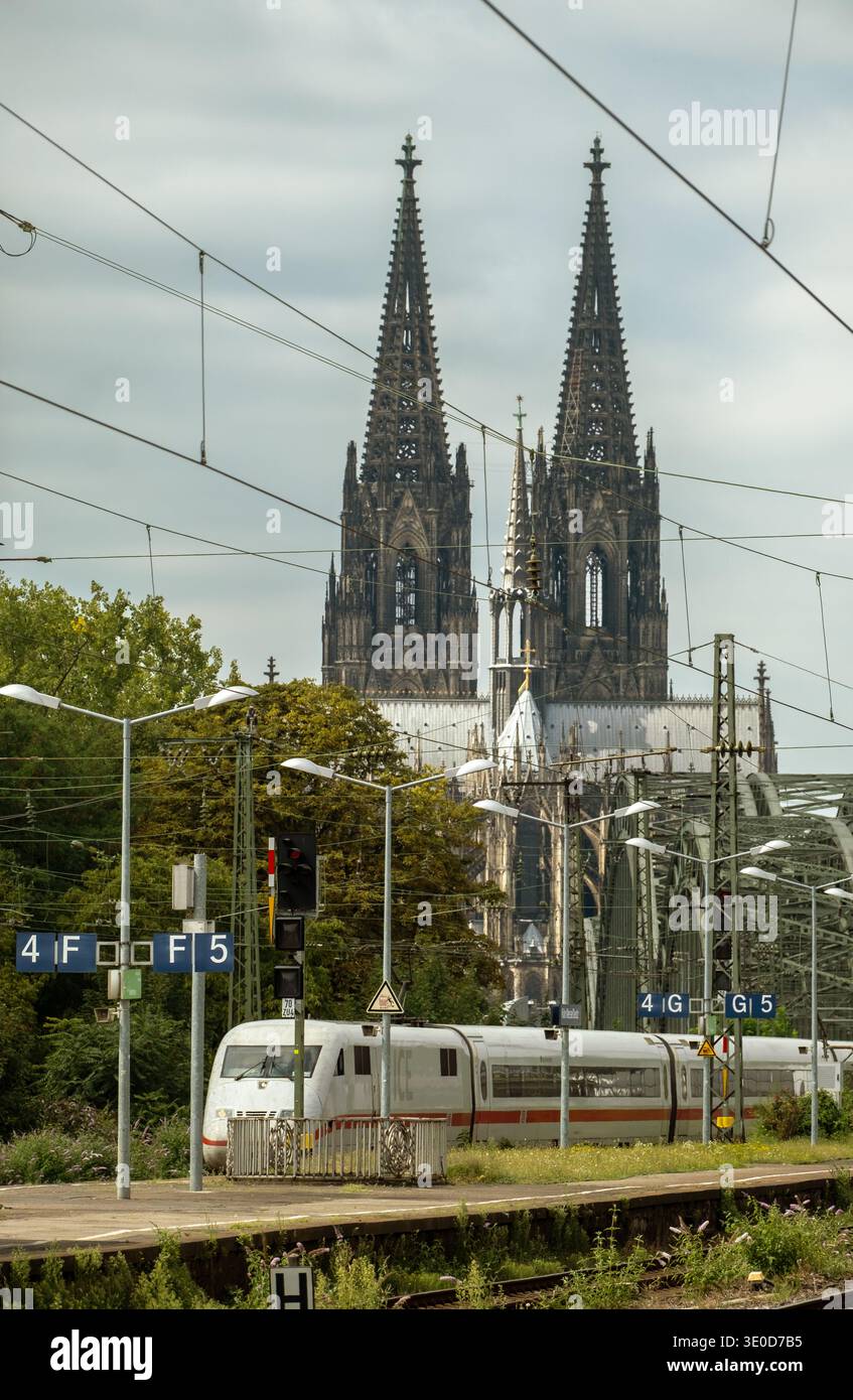 17.08.2025, Deutschland, Nordrhein-Westfalen, Köln - ICE-Zug am Bahnhof Köln Messe/Deutz vorbei, mit Rheinbrücken und Kölner Dom in Th Stockfoto