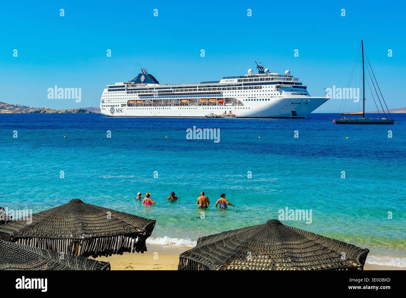 02.09.2025, Griechenland, Mykonos, Mykonos - Kreuzfahrtschiff MSC Lirica liegt in der Hafenbucht von Mykonos. Mit den Beibooten fahren Touristen an Land. Im Vorfeld Stockfoto