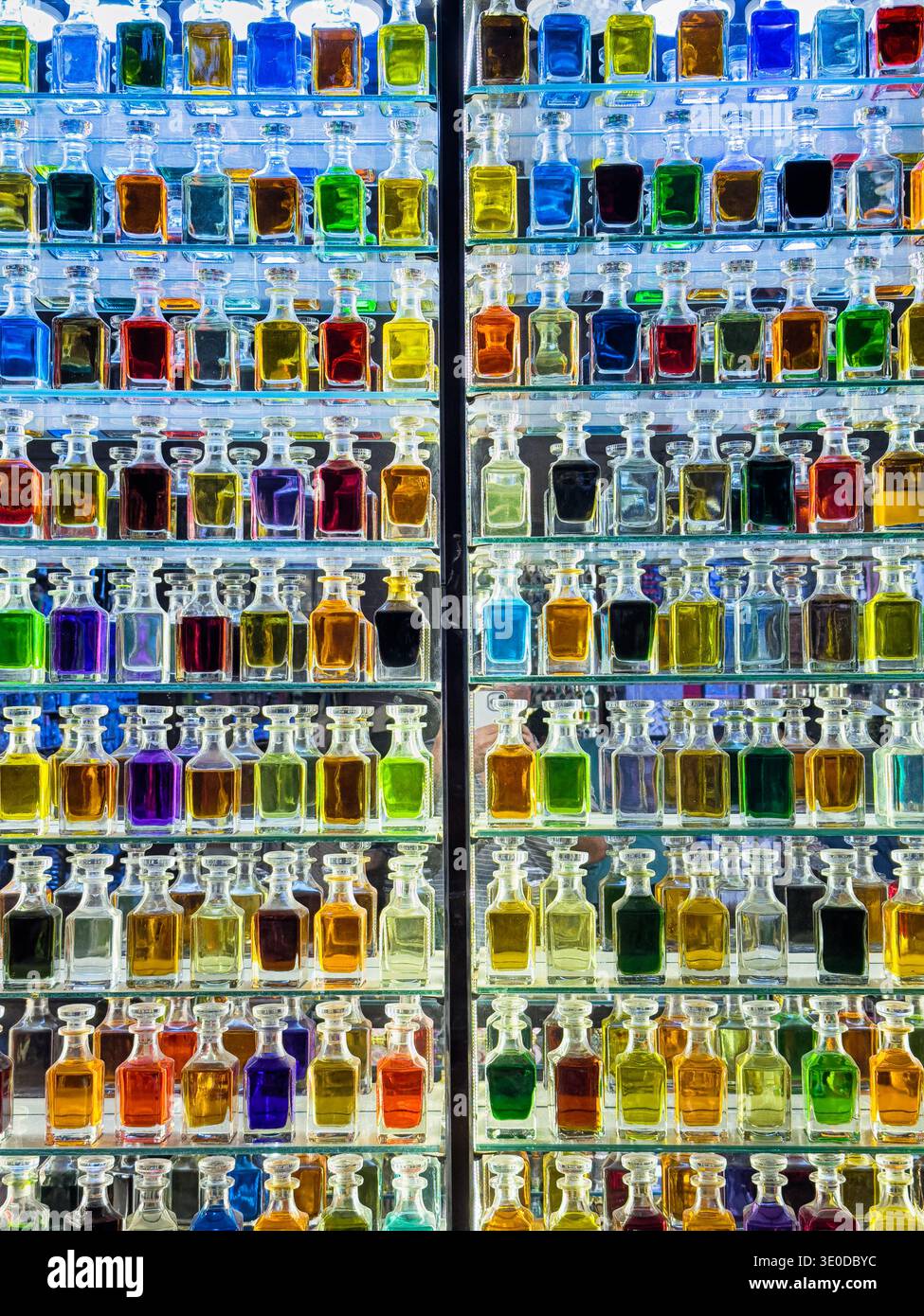 Fast 100 Flaschen Parfüm und Düfte in kleinen Glasflaschen säumen die Regale eines Ladens auf dem Gewürzmarkt von Deira. Stockfoto