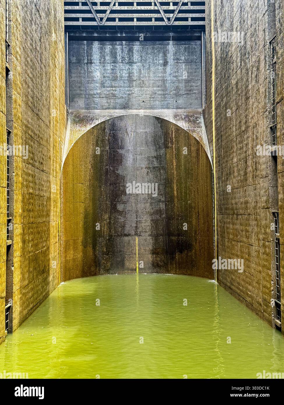 Am Fuße einer der Schleusen des Douro River leuchtet das Wasser mit einer hellgrünen Farbe. Stockfoto