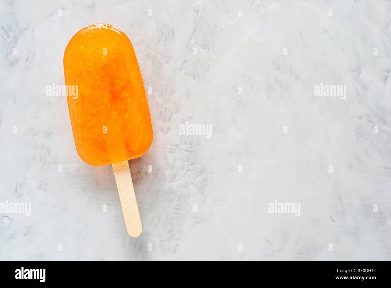 Orangeneis auf grauem Hintergrund. Stockfoto