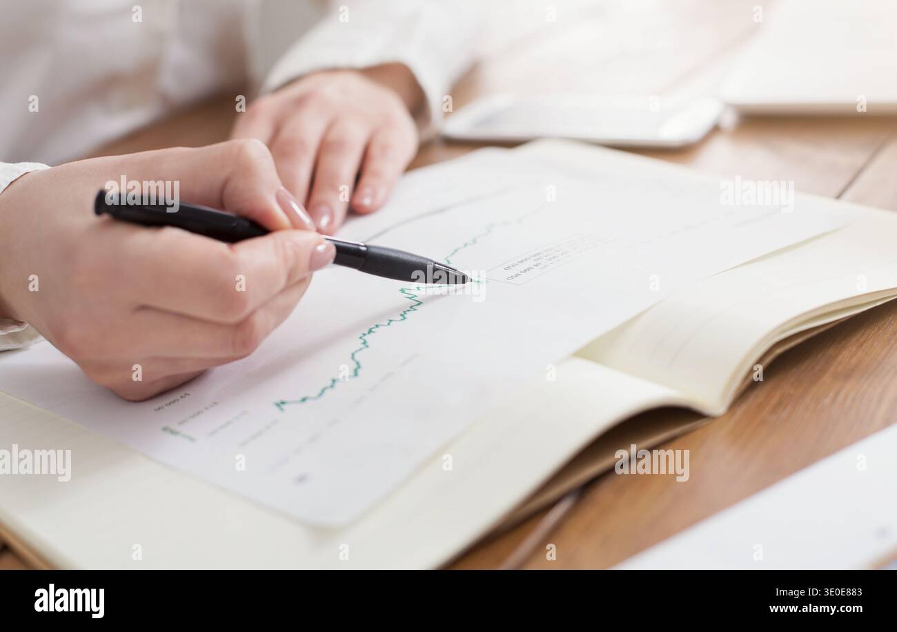Geschäftsfrau analysiert Marketinggrafiken Stockfoto