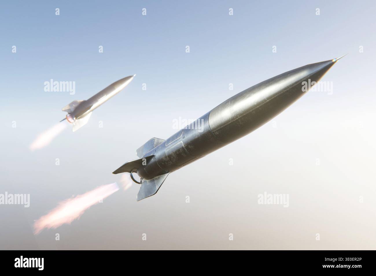 Zwei aerodynamische ballistische Raketen fliegen durch einen klaren blauen Himmel mit hellen Abgasflammen. Konzept der modernen Luft- und Raumfahrttechnik, Verteidigungssysteme Stockfoto