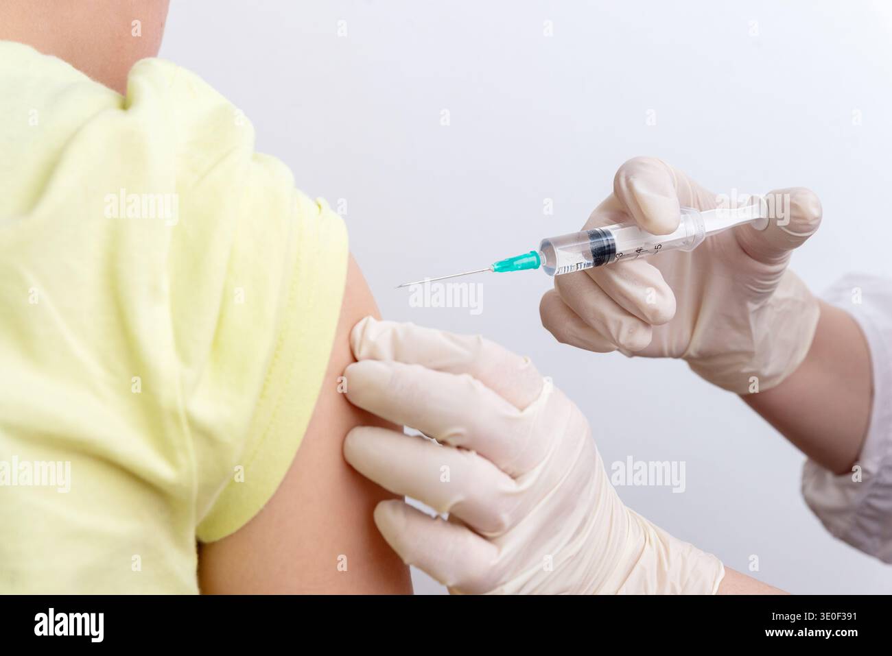 Nahaufnahme von Arzt, der den Impfstoff in den Patientenarm in der Klinik während des medizinischen Impfverfahrens injiziert Stockfoto