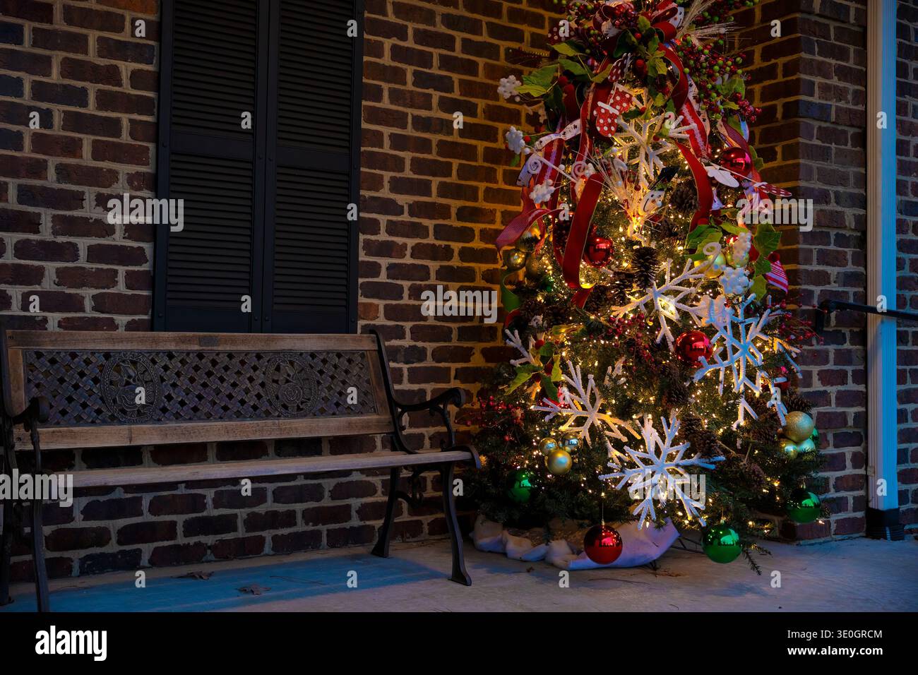 Ein geschmückter Weihnachtsbaum befindet sich vor einem Geschäft neben einer Bank im Zentrum von McAdenville, North Carolina, USA Stockfoto