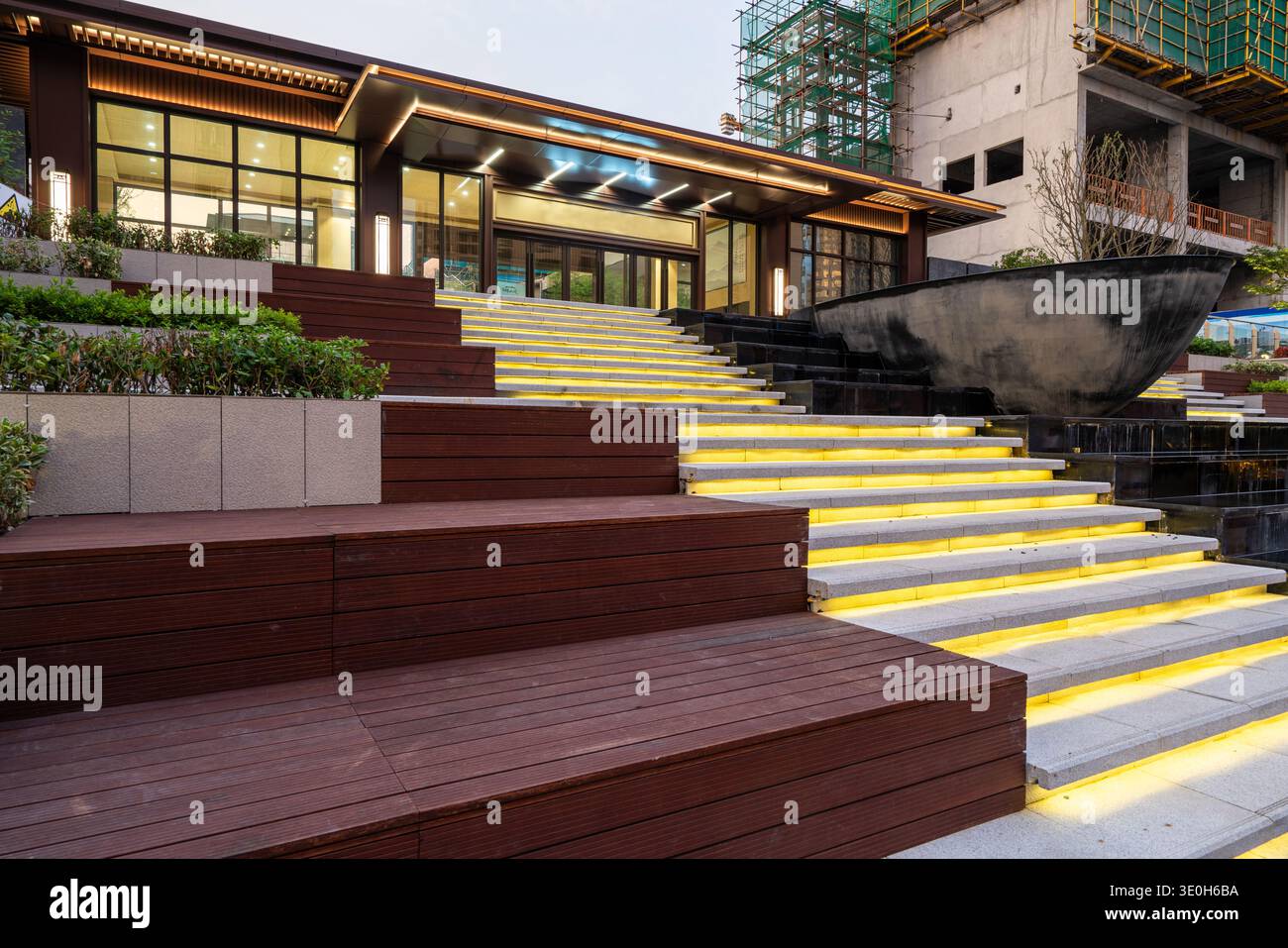 Blick auf die moderne Innentreppe, die nachts beleuchtet ist. Das Bild vermittelt architektonische Stimmung, Struktur und einladende Abendgestaltung. Hochwertiges Pho Stockfoto