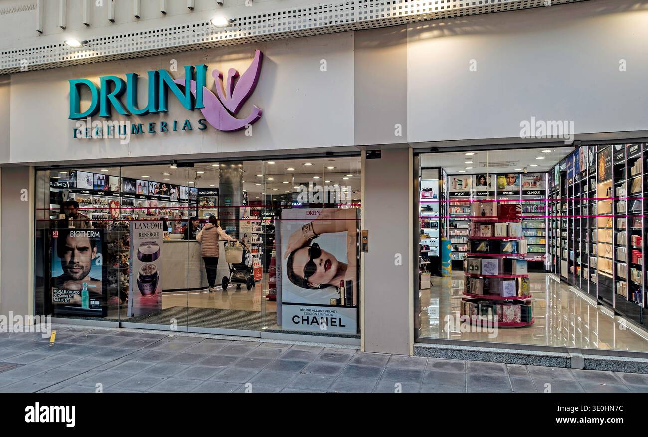 Ladenfront des Druni Perfumerías in Cartagena, Spanien, mit beleuchteten Schildern, Glasfenstern und verschiedenen Schönheitsartikeln. Stockfoto