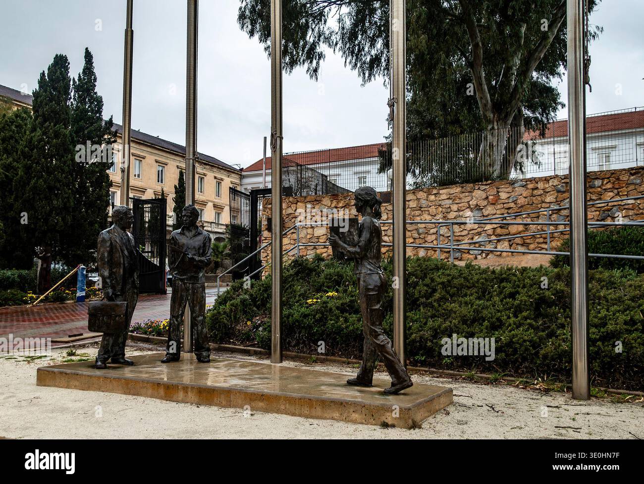 Bronzeskulpturen von Figuren an der Polytechnischen Universität von Cartagena, Spanien, im Freien an Steinmauern und Metallfahnenmasten. Stockfoto