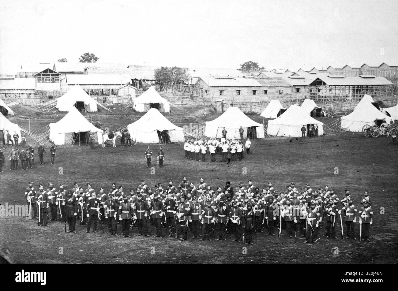 Dieses Foto aus den 1860er Jahren von Felice Beato zeigt ein Gruppenporträt des Royal Marine Battalion, wahrscheinlich in einem Lager. Das Bild zeigt zahlreiche Soldaten in Formation, mit Zelten und temporären Bauten im Hintergrund, die einen Einblick in das militärische Leben während dieser Zeit geben. Stockfoto