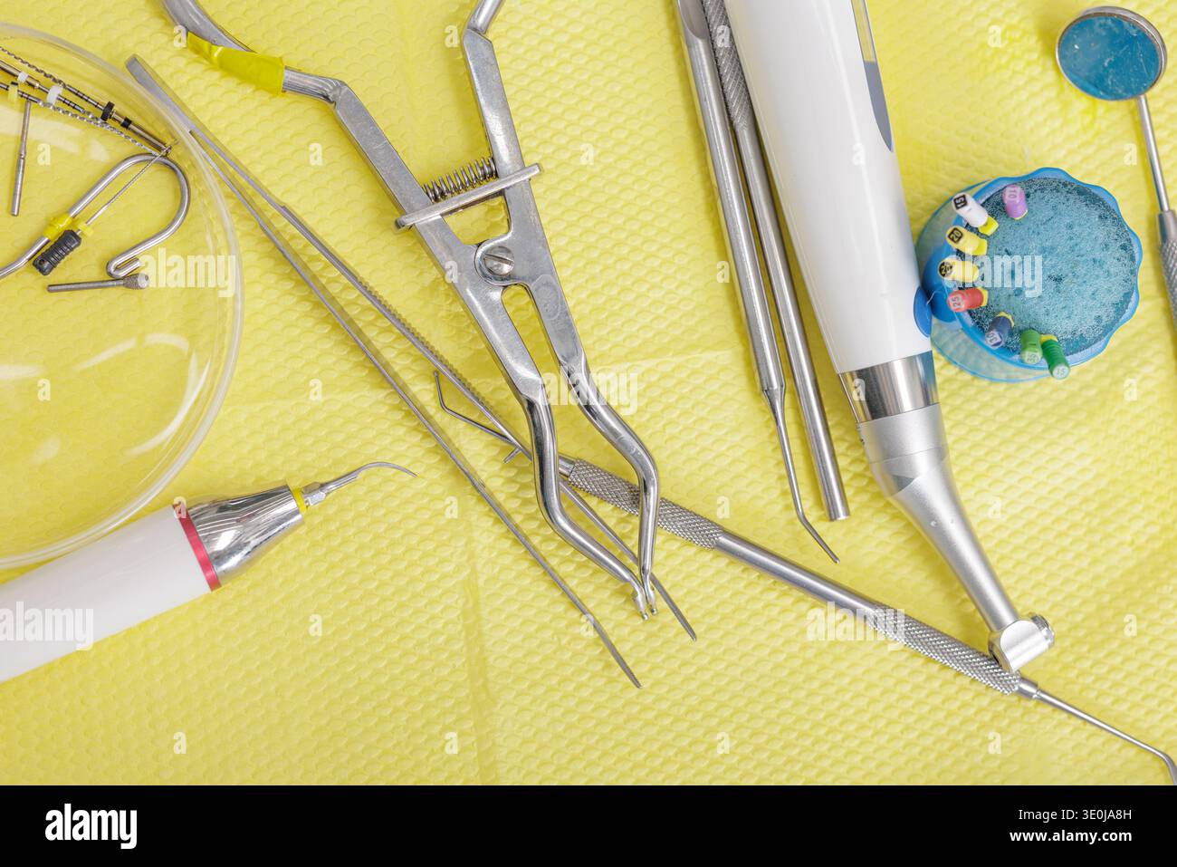 Dentalwerkzeuge, einschließlich Handstück, Feilen, Klammer und Spiegel auf steriler Oberfläche. Konzept der Endodontie, Wurzelkanalbehandlung, moderner Zahnarzt Stockfoto