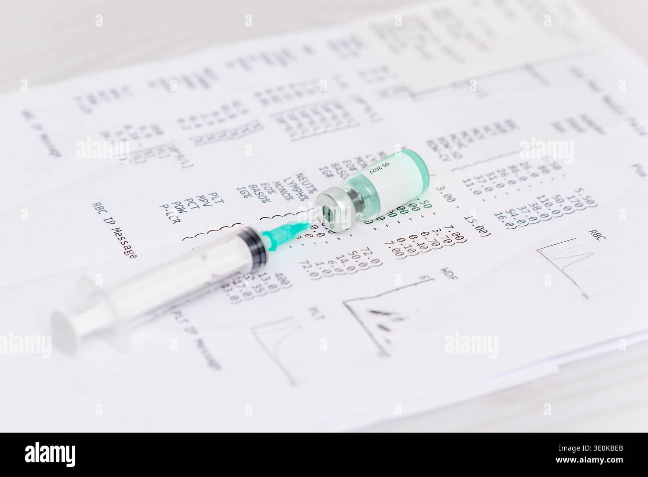 Medizinische Spritze und Impfstofffläschchen auf Bluttestlaborbericht platziert, die Gesundheitsdiagnostik und Impfforschung darstellen Stockfoto