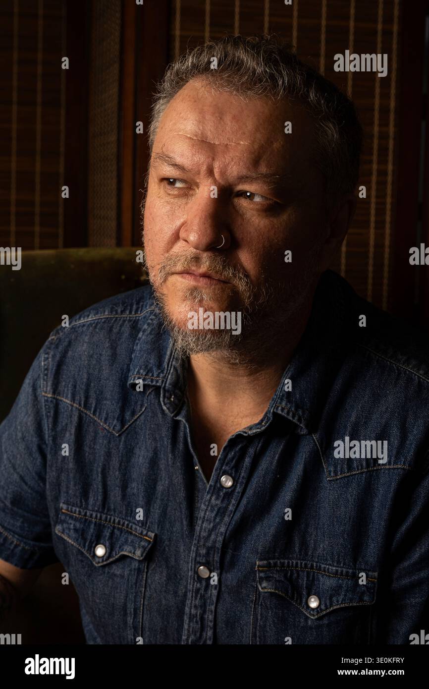 Ein 48-jähriger Brasilianer im Schatten, mit einem verdächtigen Blick in den Augen. Stockfoto