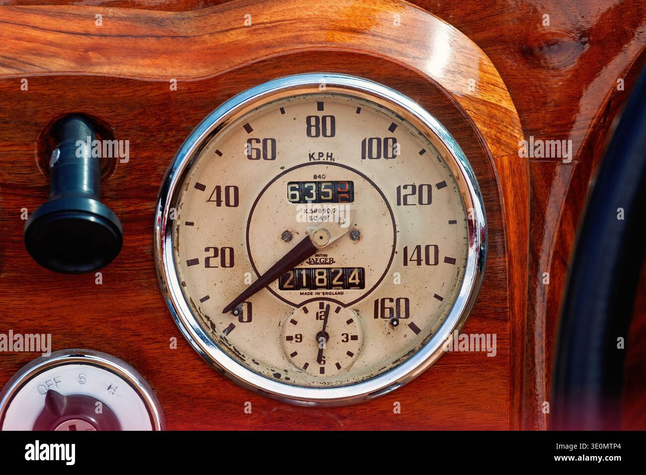 Oldtimer-Tachometer auf einem hölzernen Armaturenbrett in einem Oldtimer Stockfoto