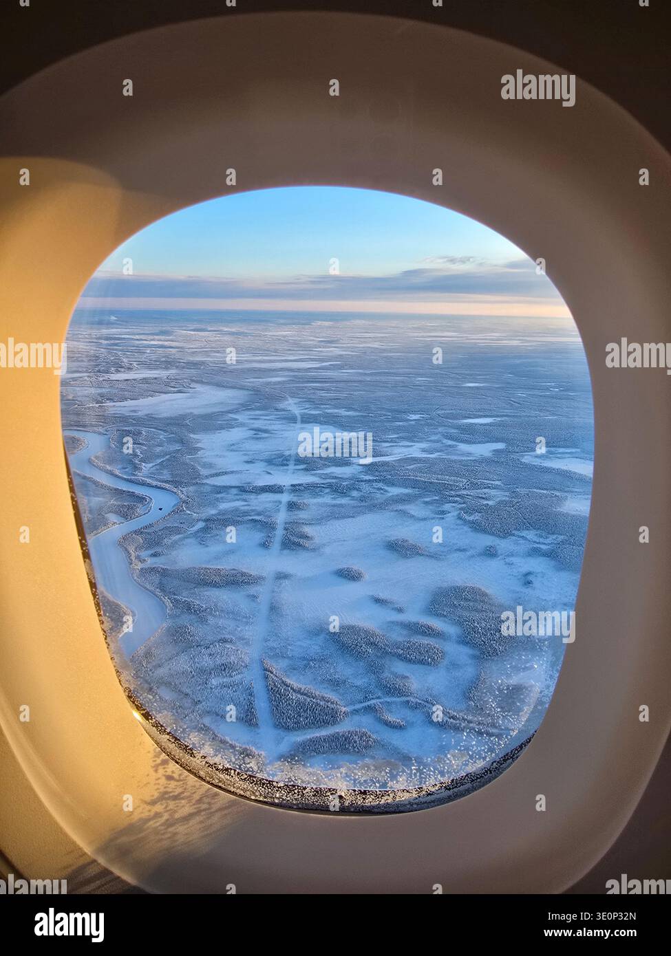 Erleben Sie die bezaubernde Schönheit Lapplands, während eisblaue Seen und weite schneebedeckte Wälder sich endlos unter Ihnen erstrecken. Dieser atemberaubende Blick aus dem Flugzeug fängt den Zauber des Winters in Finnland ein. Stockfoto