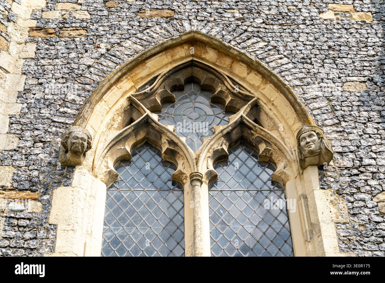St. Nikolaus in der Wade Norman Early English Church. Kurvenförmiges Tracery des östlichen Turmfensters mit Köpfen eines Königs und einer Königin an der Basis des Bogens. Stockfoto