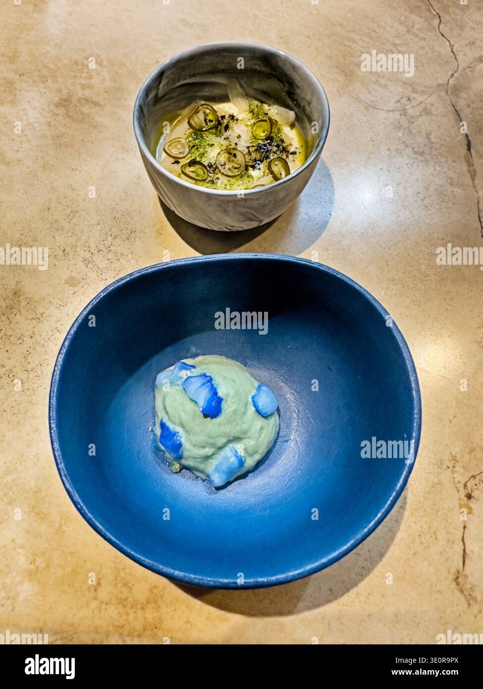 Bei einem Mittagessen in Lima, Peru, wird eine tiefblaue Schüssel mit mehreren Häppchen von Speisen überzogen. Stockfoto