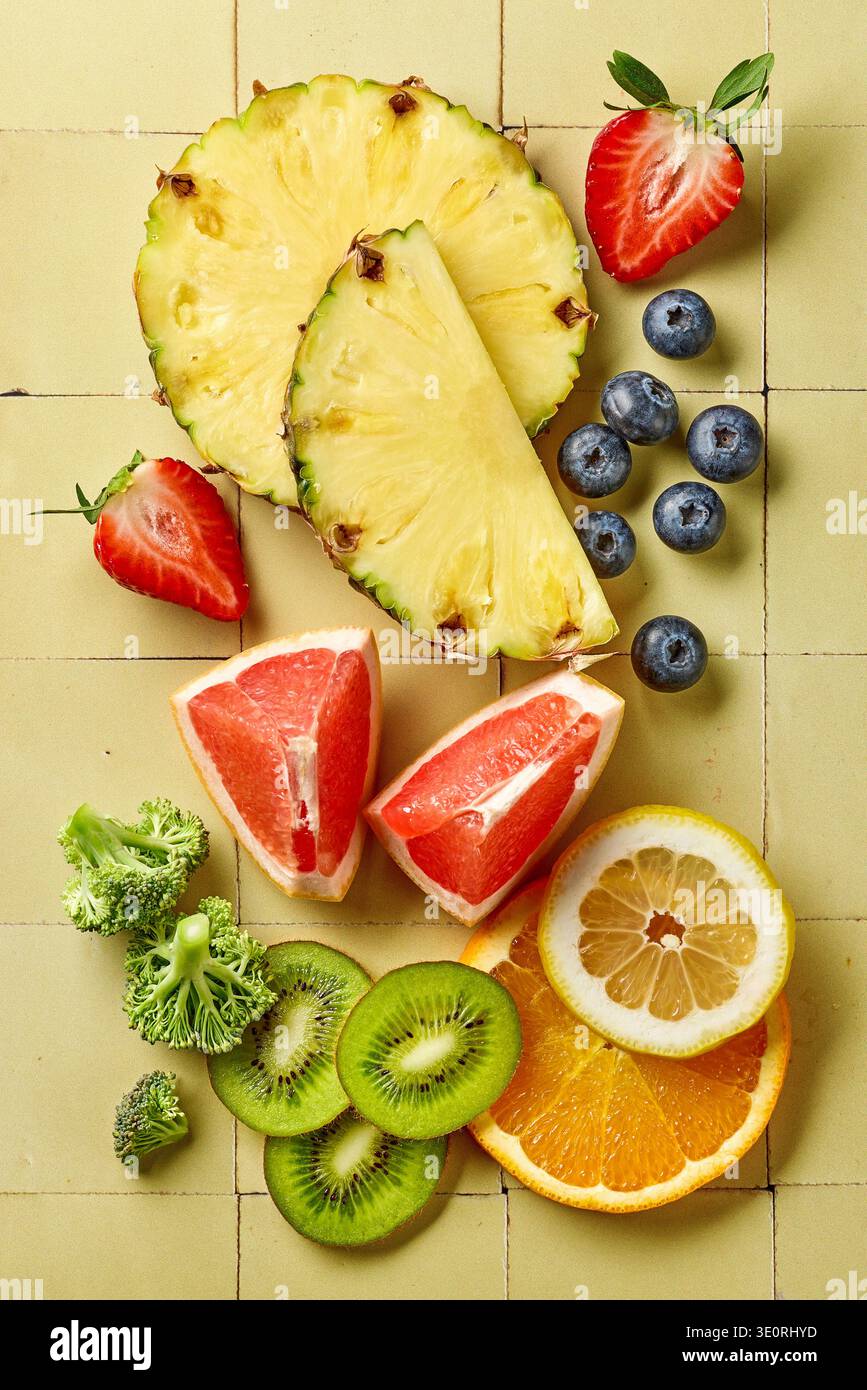 Blick von oben auf Vitamin-C-reiche Früchte und Gemüse einschließlich Orange, Zitrone, Kiwi, Erdbeeren, Grapefruit, Heidelbeeren, Ananas und Brokkoli Stockfoto