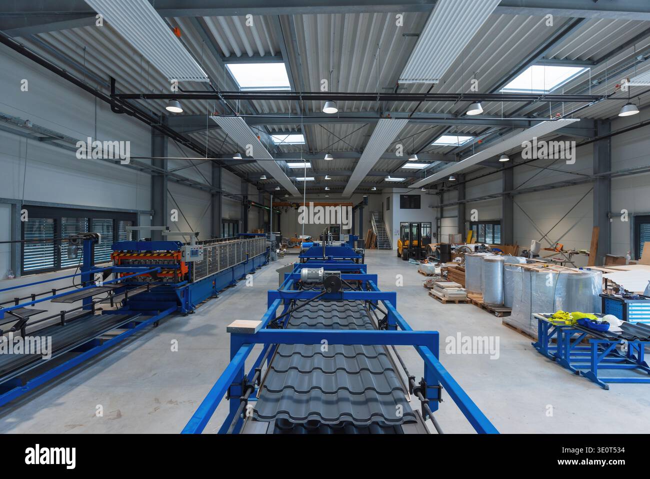Die automatisierte Produktionslinie arbeitet in einem Produktionswerk mit High-Tech-Maschinen. Das Werk ist für effiziente industrielle Arbeiten konzipiert. Stockfoto