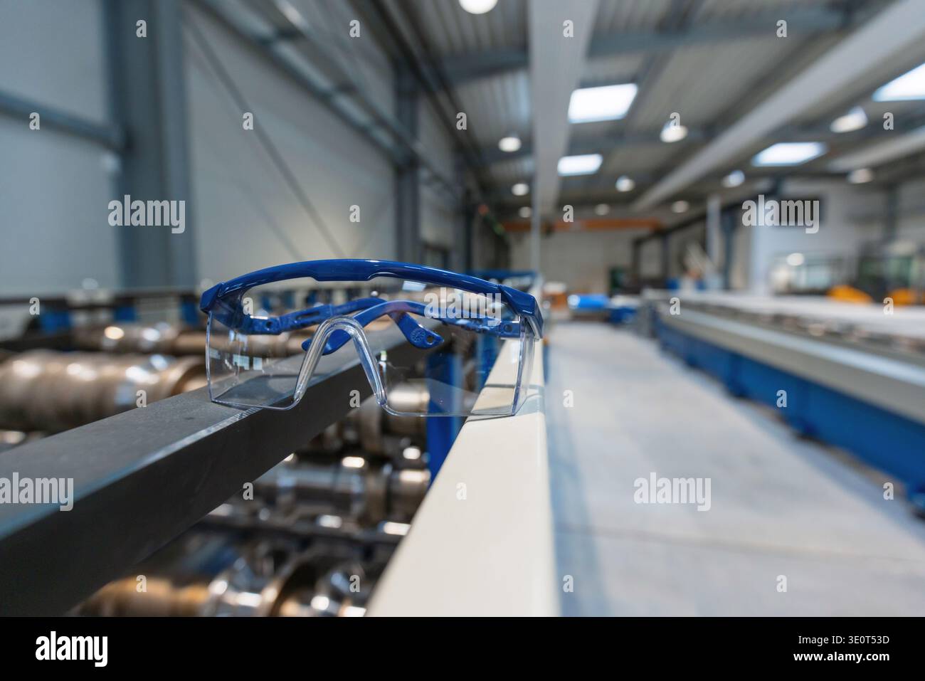 Eine moderne Produktionslinie mit Schutzbrille in einem Fertigungswerk mit fortschrittlichen Maschinen und ohne Anwesenheit von Personen. Stockfoto