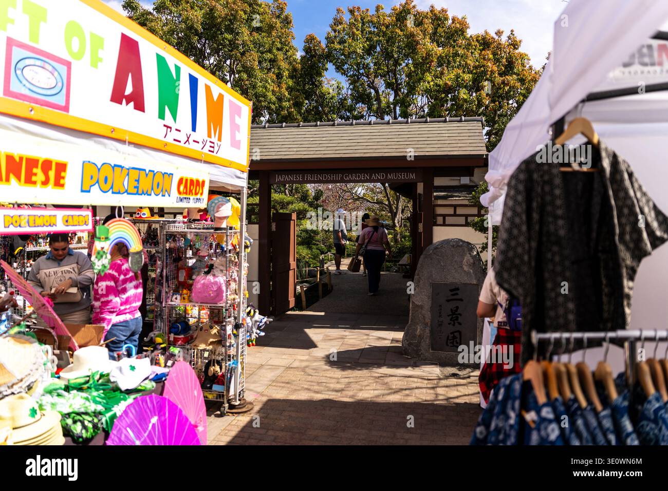 San Diego, CA, USA. März 2026. Die Teilnehmer gehen durch das Eingangstor des japanischen Freundschaftsgartens und Museums im Balboa Park, vorbei an Verkaufsständen, an denen Anime-Waren, japanische Pokémon-Karten und Happi-Mäntel verkauft werden. Das Cherry Blossom Festival 2026 feiert Hanami, die Brauch der Blumenbeobachtung, an einem ungewöhnlich heißen Wochenende. Im 12 Hektar großen Garten, der die Freundschaft zwischen San Diego und Yokohama symbolisiert, genießen die Gäste blühende Kirschbäume, eine neue Laternenwand und einen Bier- und Sake-Garten. Quelle: Tosh Persons / Alamy Live News Stockfoto