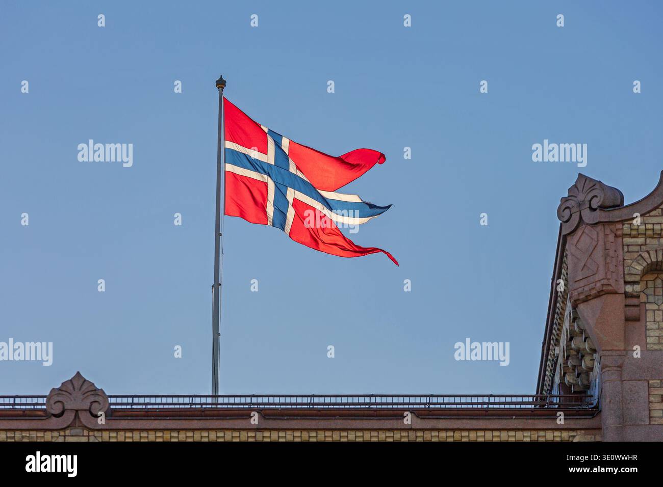 Große norwegische Flagge oben am Gebäude in Oslo sonniger Herbsttag Blauer Himmel Stockfoto