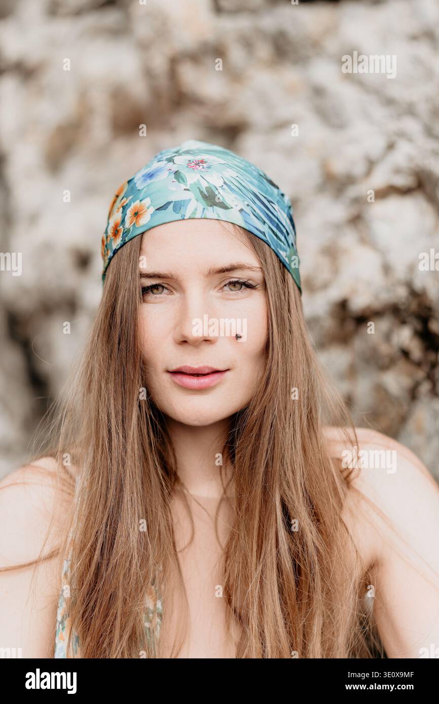 Frau Kopftuch Porträt Junge schöne Frau mit langen Haaren, die florales Bandana im Freien von felsigen Klippen mit natürlichem Licht trägt Stockfoto