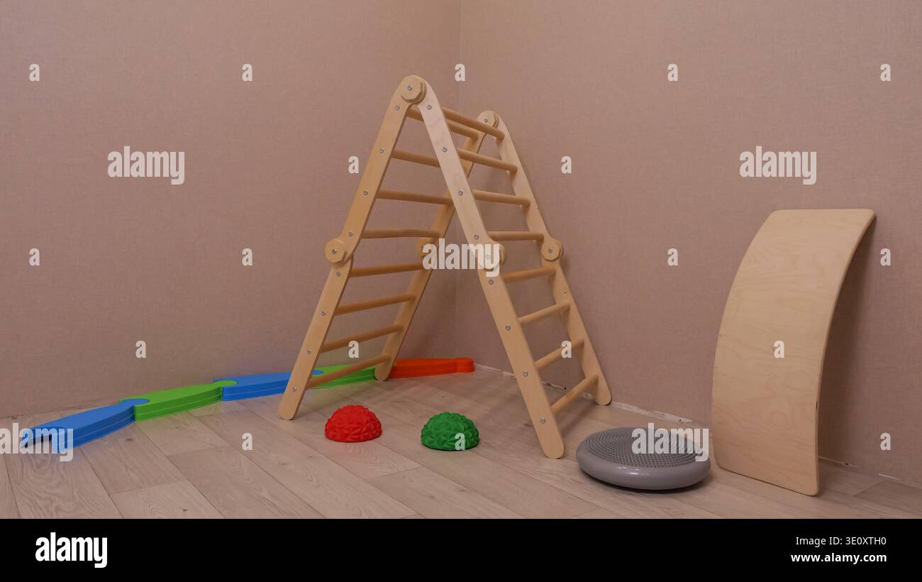 Hölzerne Kletterleiter Mit Schaumstofframpe Und Balance Pods Auf Dem Boden, Spielstation Im Innenbereich Für Die Motorischen Fähigkeiten Von Kleinkindern, Fantasievolles Spielen Und Stockfoto