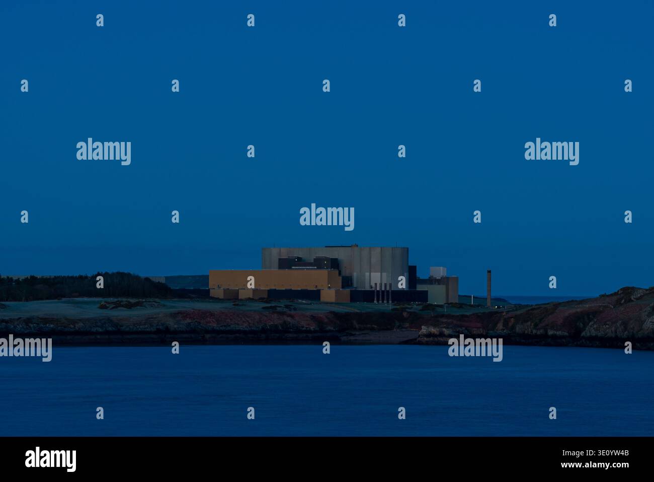 Große Industriestruktur des Kernkraftwerks Wylfa an der Küste der Cemaes Bay unter tiefblauem Himmel Stockfoto