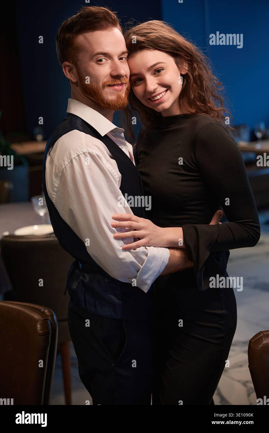 Pärchen, die abends im Restaurant lächeln Stockfoto