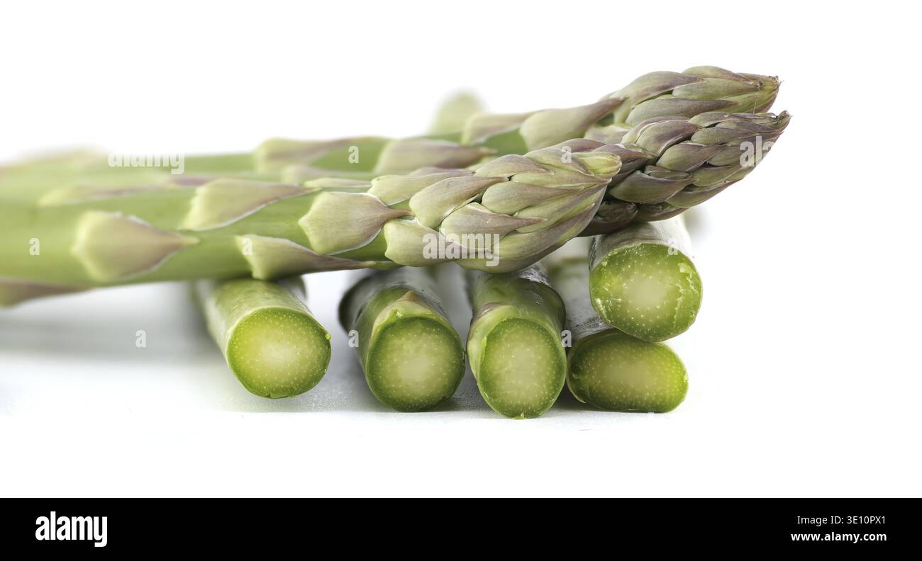Frische Spargelspeere, teilweise geschnitten, vor einem hellen weißen Hintergrund, ideal für gesunde Ernährung und kulinarische Konzepte Stockfoto
