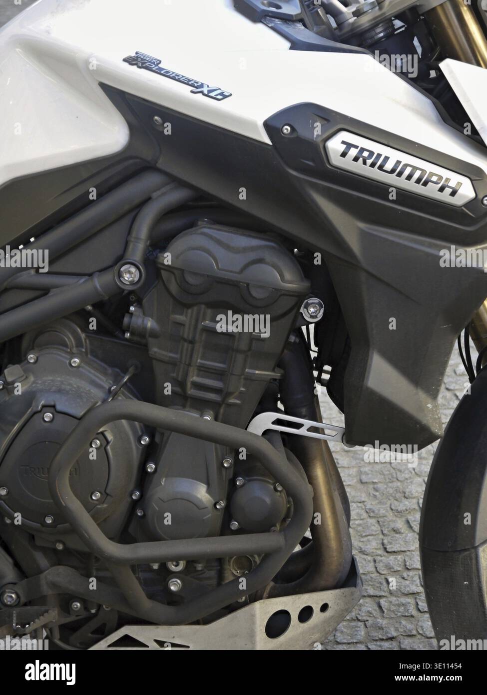 Nahaufnahme eines leistungsstarken Triumph Tiger Explorer XC Motorradmotors, der seine komplizierten Details und das markante Triumph Branding unterstreicht Stockfoto