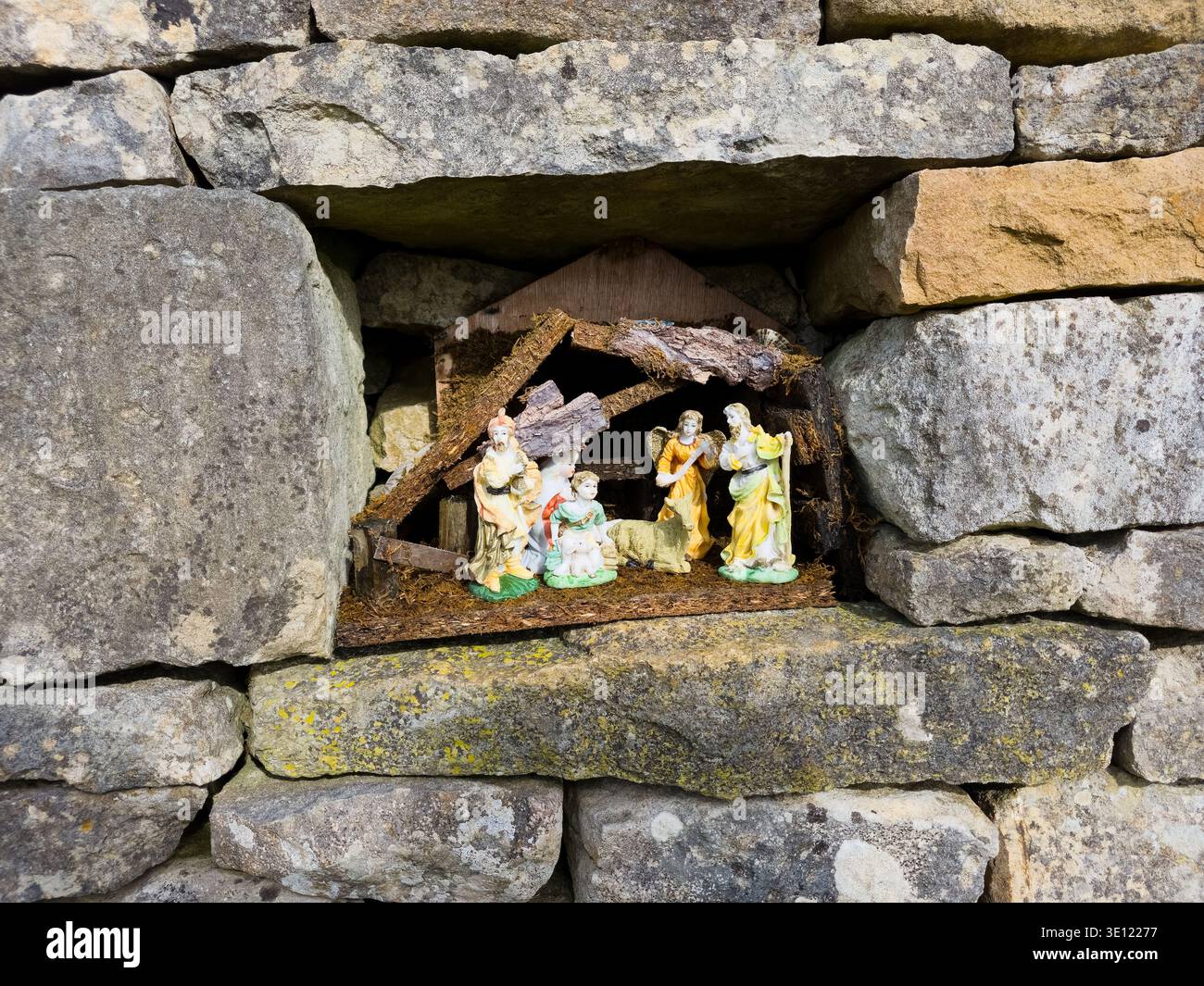 Roadside Shrine Grotto in Cotswold Stone Wall mit religiösen Figuren, Stroud Area, Gloucestershire, England Stockfoto