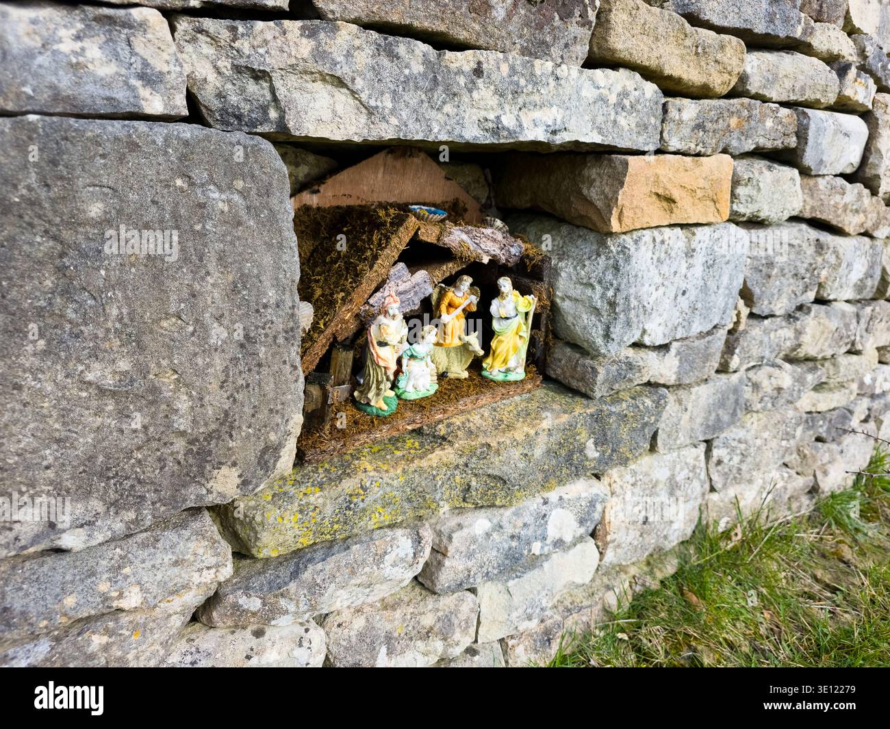Roadside Shrine Grotto in Cotswold Stone Wall mit religiösen Figuren, Stroud Area, Gloucestershire, England Stockfoto