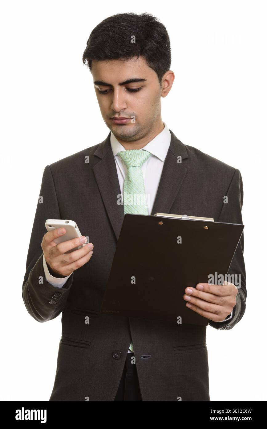 Jungen schönen persischen Kaufmanns holding Zwischenablage bei der Verwendung von Mobile phone Stockfoto