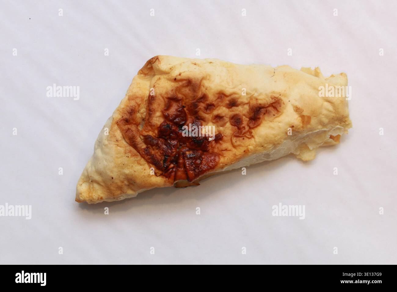 Eine köstliche Füllung in dünnem Lavash, knusprigen Kanten, weichem Fleisch und warmen Tönen. Ein einfacher, rustikaler Charme, der zur Verkostung einlädt. Gebäck auf einem weißen Stockfoto